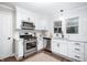 Bright kitchen features white cabinets, stainless steel appliances, and a stylish subway tile backsplash at 413 E Caven St, Indianapolis, IN 46225