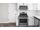 Modern kitchen featuring stainless steel oven, cooktop, white cabinets, and quartz countertops at 413 E Caven St, Indianapolis, IN 46225