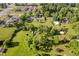 Aerial view of a large, well-manicured lot with mature trees, a home, outbuildings, and nearby community buildings at 450 W 250 N, Lebanon, IN 46052