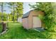 A small shed provides additional storage or hobby space surrounded by a grassy yard and mature trees at 450 W 250 N, Lebanon, IN 46052