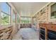 Enclosed sun room with brick walls, lots of windows, and concrete flooring at 450 W 250 N, Lebanon, IN 46052