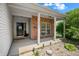 Inviting front porch with brick accents, white columns, and a welcoming entrance at 452 Southern Pines Dr, Whiteland, IN 46184