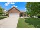 Charming brick home featuring an attached two-car garage and a well-maintained front lawn at 452 Southern Pines Dr, Whiteland, IN 46184