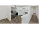 Open-concept kitchen with white cabinets, stainless steel appliances, and wood-look flooring at 5134 Rinehart Ave, Indianapolis, IN 46241
