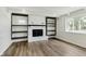 Bright living room boasts built-in shelving surrounding a fireplace and large window at 5134 Rinehart Ave, Indianapolis, IN 46241