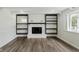 Cozy living room offers fireplace, built-in shelving and luxury vinyl plank flooring at 5134 Rinehart Ave, Indianapolis, IN 46241