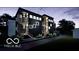 Modern two-story home with black siding, wooden accents, balconies, and professional landscaping, at night at 517 Prospect St, Indianapolis, IN 46203