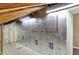 An unfinished attic features wall insulation, overhead lighting, and sloped ceilings at 5225 Thompson Park, Indianapolis, IN 46237