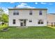 Spacious backyard featuring a patio, fire pit, lush green grass, and easy access to the home through sliding glass doors at 5225 Thompson Park, Indianapolis, IN 46237
