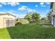 Wide backyard showcasing a shed, picnic table, and a firepit area with serene views of the pond and surrounding greenery at 5225 Thompson Park, Indianapolis, IN 46237