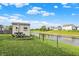 Spacious backyard with a shed, picnic table and umbrella by a pond, great for relaxation and outdoor activities at 5225 Thompson Park, Indianapolis, IN 46237