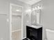 Well-lit bathroom with a modern vanity, mirror, stylish lighting, and a glimpse into a walk-in closet at 5225 Thompson Park, Indianapolis, IN 46237