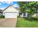 Charming single-story home with a well-maintained lawn and attached two-car garage at 5225 Thompson Park, Indianapolis, IN 46237
