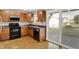Cozy kitchen with wood cabinets, black appliances, and a sliding door to the backyard at 5225 Thompson Park, Indianapolis, IN 46237