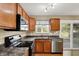 Bright kitchen with wood cabinets, stainless steel dishwasher, and a view to the backyard at 5225 Thompson Park, Indianapolis, IN 46237