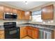 Updated kitchen with wood cabinets, stainless steel dishwasher, and an electric stovetop at 5225 Thompson Park, Indianapolis, IN 46237