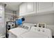 Bright laundry room featuring a washing machine, dryer, water heater, and storage cabinets at 5225 Thompson Park, Indianapolis, IN 46237