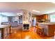 Open-concept kitchen and living area featuring warm wood floors and matching kitchen island with seating at 5387 E County Road 800 S, Mooresville, IN 46158