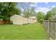 Expansive backyard featuring a lush lawn, detached garage, and wooden fence, perfect for outdoor enjoyment and privacy at 5715 Oak Ave, Indianapolis, IN 46219