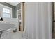 Bathroom with white tile floor, open shower, and shelving for storage at 5715 Oak Ave, Indianapolis, IN 46219