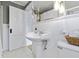 Traditional white bathroom features a pedestal sink, beadboard wainscoting, and decorative lighting fixture at 5715 Oak Ave, Indianapolis, IN 46219