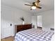 Bedroom with ceiling fan, hardwood floors, dresser with decorations and bed with blanket at 5715 Oak Ave, Indianapolis, IN 46219