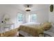 Sunlit bedroom featuring hardwood floors, complemented by two windows, vanity, and coordinated bedding at 5715 Oak Ave, Indianapolis, IN 46219
