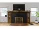 A decorative brick fireplace with wooden mantle, cabinets, and mounted TV above at 5715 Oak Ave, Indianapolis, IN 46219