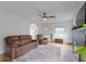 Bright living room featuring a leather sofa, ceiling fan, and decorative fireplace at 5715 Oak Ave, Indianapolis, IN 46219