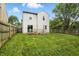 A shot of the backyard with a grassy lawn, wood fence, and the back of the house at 6495 Titania Dr, Indianapolis, IN 46236