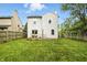 The backyard is spacious and contains a grassy lawn, a wooden fence, and the back of the house at 6495 Titania Dr, Indianapolis, IN 46236
