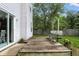 Backyard with wooden deck, bench, a sliding glass door, and lush greenery at 6495 Titania Dr, Indianapolis, IN 46236