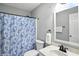 Bathroom with floral shower curtain, toilet, and white vanity with modern fixtures at 6495 Titania Dr, Indianapolis, IN 46236