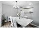 Dining area featuring a modern chandelier, a white table, and access to the kitchen area at 6495 Titania Dr, Indianapolis, IN 46236