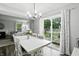 Dining area with a white table, chairs, and a view into the living room and backyard at 6495 Titania Dr, Indianapolis, IN 46236
