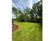 Large backyard featuring well-maintained lawn and mature trees, offering privacy and space for outdoor activities at 6611 Wandering Way, Indianapolis, IN 46241