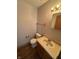 This bathroom features a single sink vanity, toilet, mirror, and wood look flooring at 6611 Wandering Way, Indianapolis, IN 46241