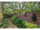 Tranquil brick-walled courtyard with water feature, lush greenery, and a brick path creating a serene outdoor retreat at 6733 Jons, Zionsville, IN 46077