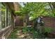 Secluded brick-walled garden with birdbath, brick pathway, and lush foliage, offering a private and peaceful outdoor sanctuary at 6733 Jons, Zionsville, IN 46077