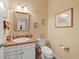 Bathroom with single sink vanity, white cabinets, wicker mirror, and decorative artwork at 6733 Jons, Zionsville, IN 46077