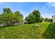 Lush backyard with a fire pit, mature trees, and sheds for ample storage at 6848 Harriet Dr, Indianapolis, IN 46237