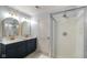 Bathroom featuring double sinks with gold trimmed mirrors and modern shower at 6848 Harriet Dr, Indianapolis, IN 46237