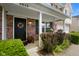 Charming front porch with brick columns, a decorative wreath, and lush greenery at 6848 Harriet Dr, Indianapolis, IN 46237