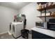 Functional laundry room with side by side washer and dryer, shelving, and storage space at 6848 Harriet Dr, Indianapolis, IN 46237