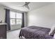 This bedroom has neutral walls, a ceiling fan, and a window letting in natural light at 6902 Diamondleaf Way, Brownsburg, IN 46112