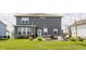 Back exterior of the home with a patio and landscaping, surrounded by a large, green lawn at 6902 Diamondleaf Way, Brownsburg, IN 46112