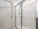 Modern bathroom shower featuring frameless glass doors, chrome fixtures, and white tile at 6902 Diamondleaf Way, Brownsburg, IN 46112