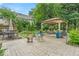 Landscaped backyard featuring a stone patio, gazebo, and outdoor seating at 7502 Colony Cir, Indianapolis, IN 46260