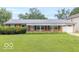 Charming single-story brick home with a well-manicured lawn, covered porch, and attached garage at 814 N Noble St, Greenfield, IN 46140
