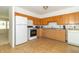 Kitchen featuring wooden cabinets, white appliances, and tile flooring at 814 N Noble St, Greenfield, IN 46140